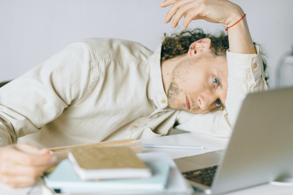 sad male office worker collapses on his arm in frustration